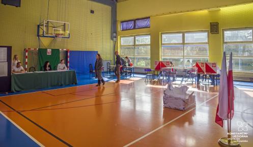 Sal gimnastyczna ze stojącą na jej środku urną wyborczą.