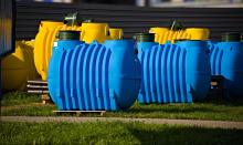 Plastikowe zbiorniki, żółte i niebieskie, do przydomowych oczyszczalni ścieków