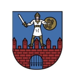 Herb na tarczy, na niebieskim tle na dole fragmenty czerwonych murów miejskich z bramą, na których stoi rycerz w białym stroju z mieczem w prawej ręce i tarczą w lewej. 