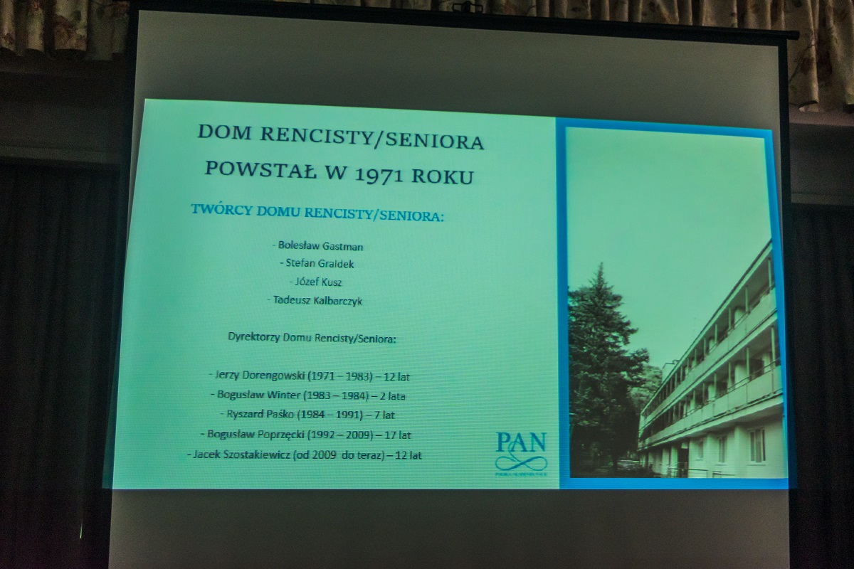 Sala. Na projektorze wyświetlany jest slajd, na którym jest napis Dom Rencisty/Seniora powstał w 1971 roku. Poniżej wymienieni są twórcy oraz dyrektorzy Domu Rencisty/Seniora.