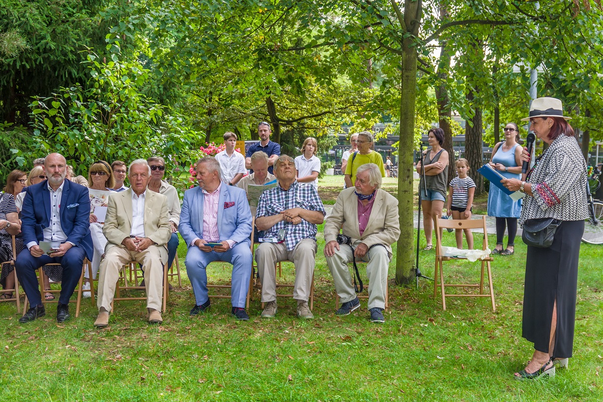Grupa ludzi siedzaca na krzesłach na świezym powietrzu, w tym Pan burmistrz. 