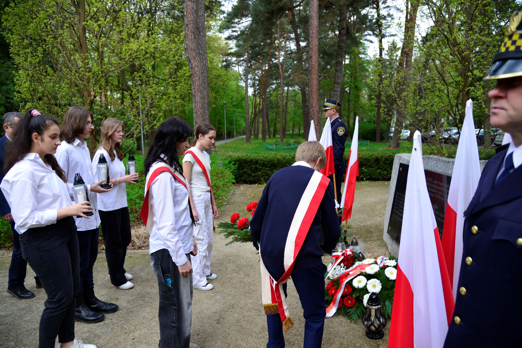 Zdjęcia relacjonujące uroczystości z okazji 84. rocznicy zbrodni katyńskiej, prezentujące osoby składające kwiaty przed pomnikiem katyńskim.   