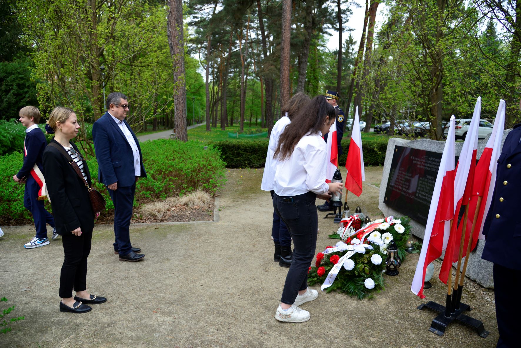 Zdjęcia relacjonujące uroczystości z okazji 84. rocznicy zbrodni katyńskiej, prezentujące osoby składające kwiaty przed pomnikiem katyńskim.   