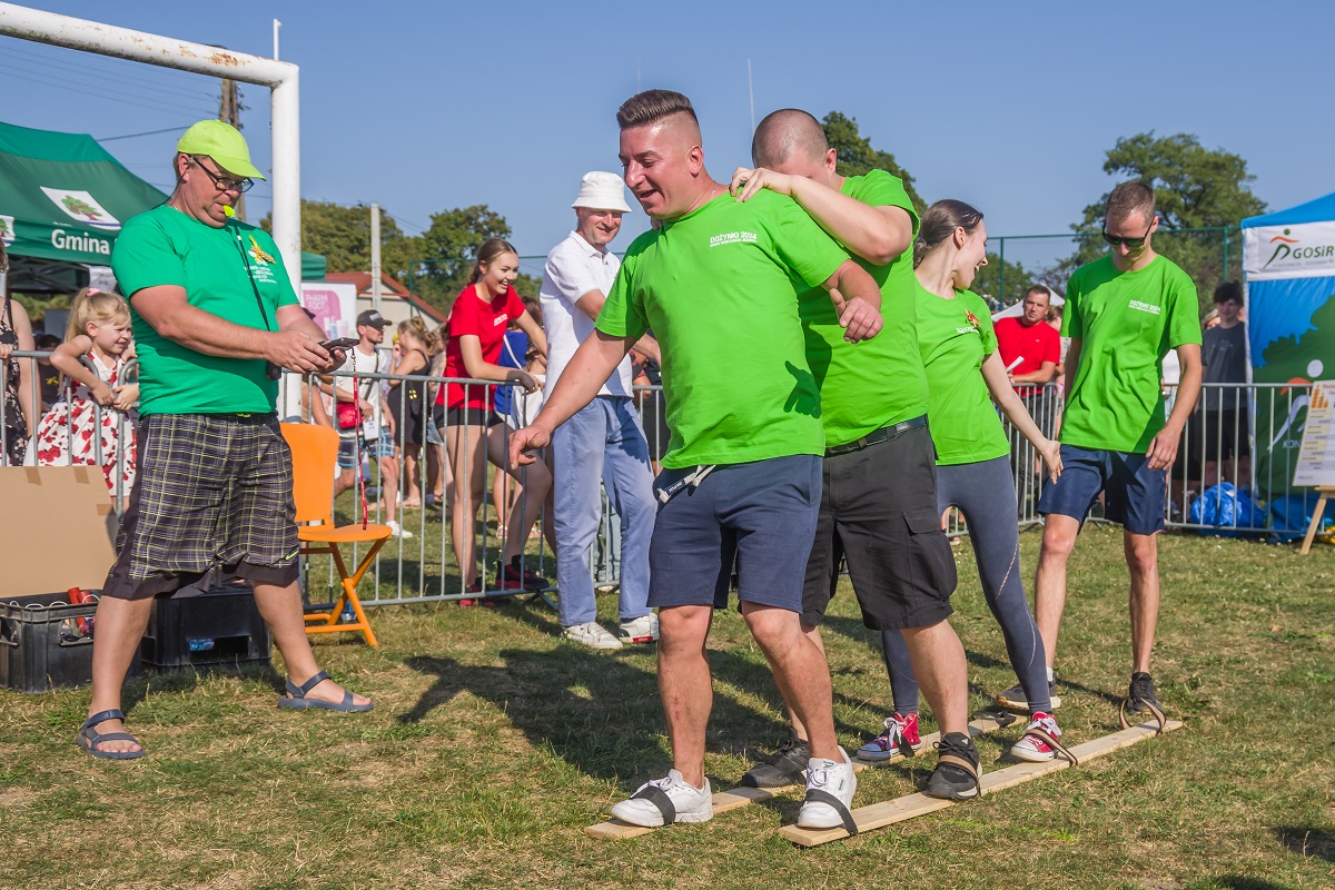 grupka osób ubrana w zielone koszulki uczestniczą w sportowej konkurencji