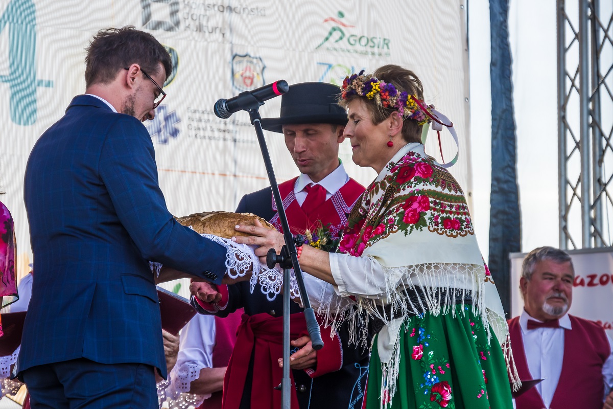 burmistrz przekazuje chleb kobiecie i mężczyźnie ubranych w strojach ludowych