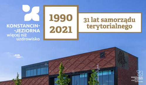 Z lewej strony znak promocyjny Konstancin-Jeziorna więcej niż uzdrowisko, pośrodku na kwadratowym polu daty 1990 2021, obok napis 31 lat samorządu terytorialnego, pod nimi nowoczesny obiekt z czerwonej cegły z licznymi oszkleniami