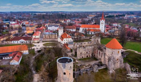 Widok z lotu ptaka miasta ze starą zabudową, na pierwszym planie budowla sakralna z wysoką wieżą, w tle widoczne fragmentu budowli zamkowej