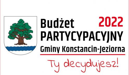 z lewej strony herb gminy: tarcza herbowa jest biała. Widnieje na niej drzewo – dąb – z brązowym korzeniem i pniem oraz zieloną koroną. Pod drzewem znajduje się pięć błękitnych fal symbolizujących rzekę Jeziorkę. z prawej strony napis Budżet partycypacyjny Gminy Konstancin-Jeziorna 2022, Ty decydujewsz!