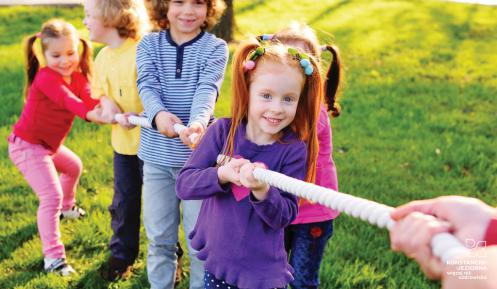 Pięcioro dzieci w wieku szkolnym bierze udział w zabawie ciągnięcia liny. 