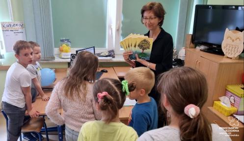 Dyrektorka Szkoły Podstawowej nr 3 Katarzyna Hampel stoi w klasie wśród uczniów, trzyma w ręku książki.