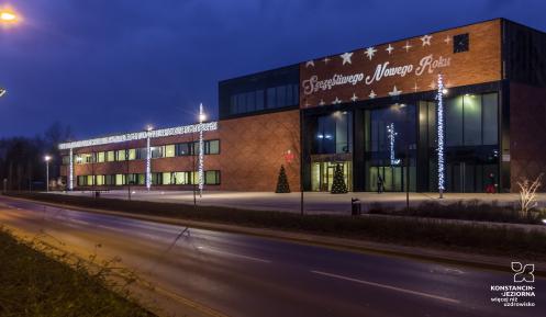 Budynek ratusza w Konstancinie-Jeziornie, na elewacji wyświetlany napis Szczęśliwego Nowego Roku.