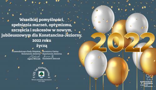 Grafika wektorowa. Na błękitnym tle białe i złote balony oraz gwiazdki. Z lewej strony życzenia od władz gminy, ich treść podana jest w artykule. Poniżej życzeń herb gminy, wokół którego umieszczono tekst: 125 lat Konstancina i 105 lat uzdrowiska Konstancin.