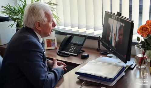 Mężczyzna siedzący przy biurku patrzy w ekran monitora komputerowego.