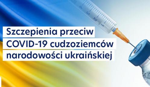 Grafika. Na tle Ukraińskiej flagi (niebiesko–żółtej) umieszczony został tekst – szczepienia przeciw COVID-19 cudzoziemców narodowości ukraińskiej. Po prawej stronie widoczna jest ampułka i strzykawka. 