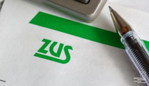 Kartka z logo ZUS, na której leży długopis.
