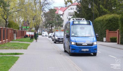 Niebieski autobus lokalnej linii L28 w czasie przejazdu.