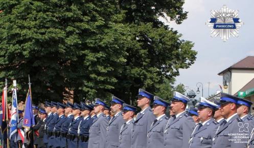 Funkcjonariusze w umundurowaniu stoją na baczność w rzędzie. 