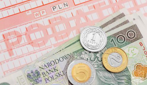 Druk przelewu podatku, na którym leżą banknoty i monety o różnych nominałach.