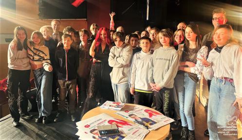 Zdjęcie z grupą dziewczynek i chłopaków (nastolatków). Przed Nimi na stoliku plakaty promujace akcję Eco Studio.