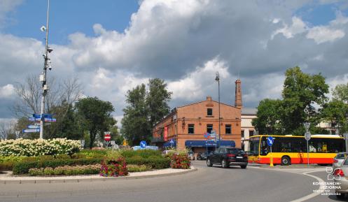 Przestrzeń miejska - ulica. W tle budynek z czerwonej cegły.