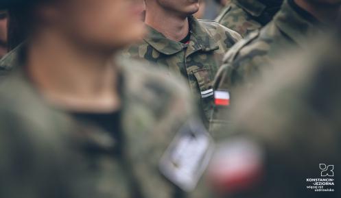Zdjęcie przedstawia rozmazane sylwetki trzech męzczyzn w mundurach Wojska Polskiego.
