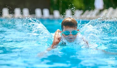 Chłopiec w goglach płycie w basenie.