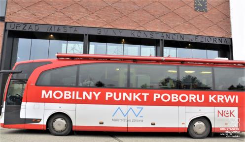 Autobus krwiodawca zaparkowany przed magistratem.  