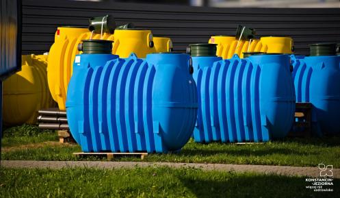 Plastikowe zbiorniki, żółte i niebieskie, do przydomowych oczyszczalni ścieków