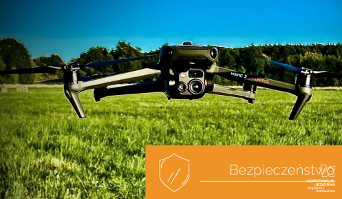 Dron z kamerą nad polaną, w tle drzewa
