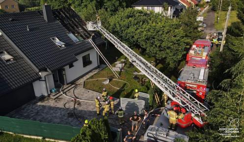 Strażacy podczas akcji gaśniczej pożaru budynku jednorodzinnego