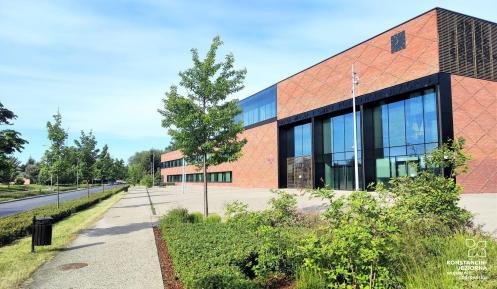 Wysoki budynek z czerwonej cegły z przeszklonymi oknami