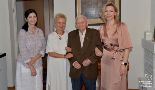 Cztery osoby pozują do zdjęcia na tle ściany 