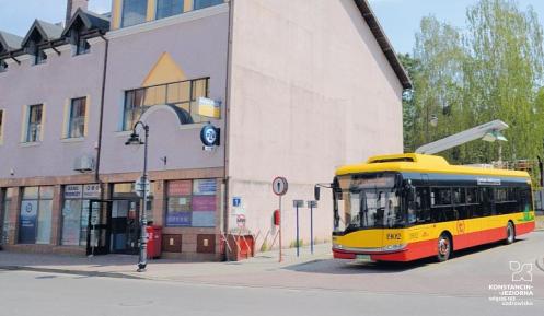 autobus na tle budynku, na ścianie ślady po zdemontowanych reklamach