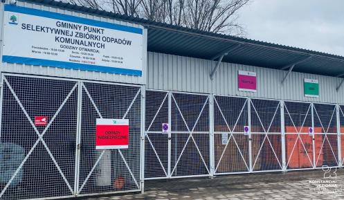 Obiekt zbudowany z elementów metalowych, z frontu widoczne zamykane drzwi z siatką oraz tabliczki z napisami