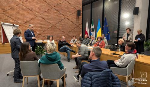 Grupa ludzi siedząca w sali