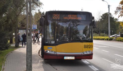 Autobus linii 251 z napisem Metro Wilanowska stojący na przystanku autobusowym.