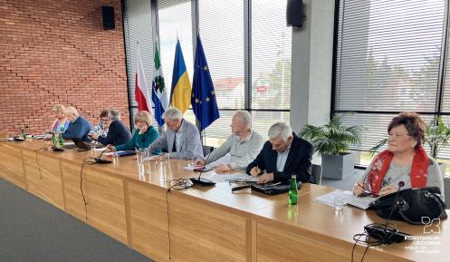 Grupa osób siedzi przy stole.