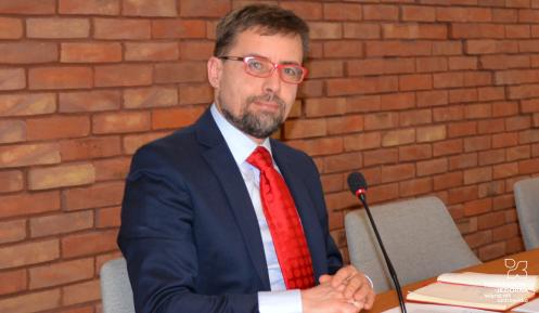 Burmistrz na tle ściany z czerwonej cegły.