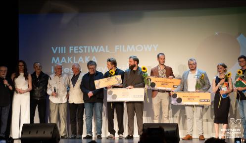 Zdjęcie zbiorowe nagrodzonych osób na festiwalu - stoją na scenie w Hugonówce.