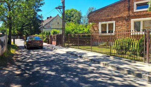 Nowy chodnik na ulicy miejskiej, w tle budynki