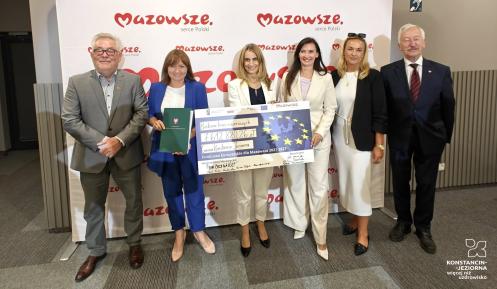 Grupa ludzi trzyma czek