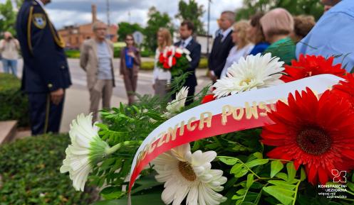 Zdjęcie reprezentantów samorządu składającego kwiaty przed pomnikiem powstanców.