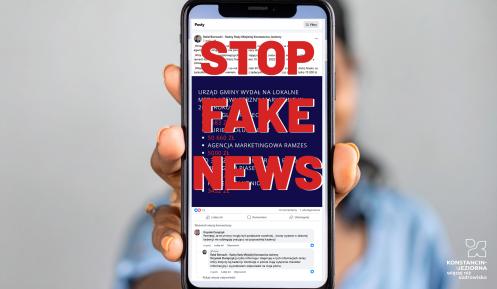 Osoba trzymająca telefon z napisem Stop Fake News