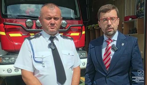 Dwóch mężczyzn na tle wozu strażackiego 