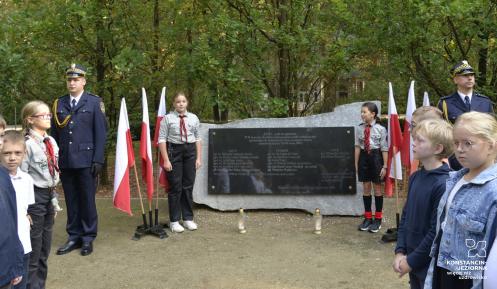Grupa dzieci przez pomnikiem katyńskim.