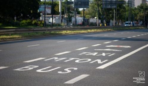 Fragment ulicy z wydzielonym pasem ruchu oznaczonym jako buspas, przeznaczonym dla autobusów, taksówek i motocykli.
