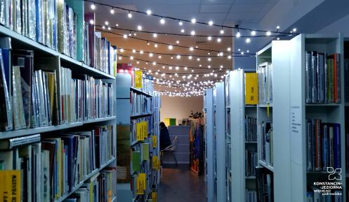 półki w bibliotece oświetlone światełkami