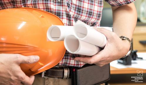 architekt trzymający plan i kask
