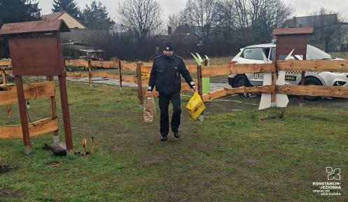 Strażnik miejski niosący reklamówi w darami.