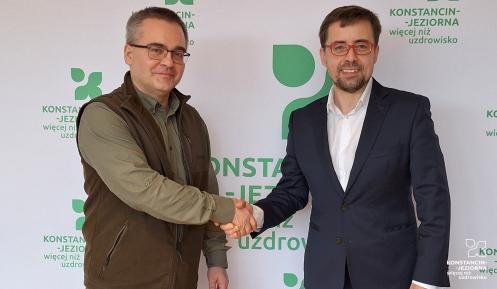 Dwie osoby podają sobie rękę z gratulacjami